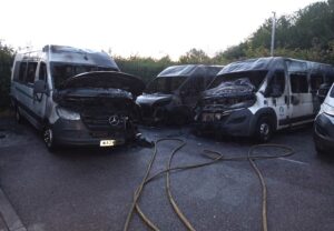 Burnt minibuses in a compound following a suspected arson attack in Taunton, Somerset.